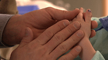 Doctor touches Tess Blackwelder's hands - Cincinnati Children's Hospital